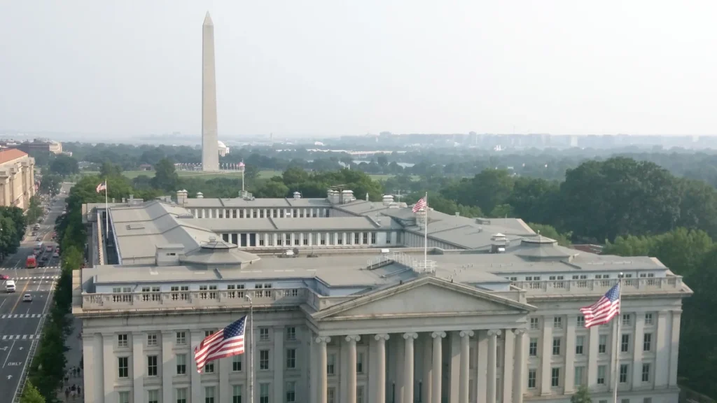 U.S. Treasury Building in Washington, D.C., with the Washington Monument in the background.