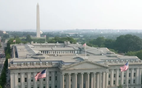U.S. Treasury Building in Washington, D.C., with the Washington Monument in the background.