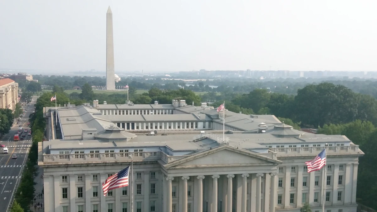 U.S. Treasury Building in Washington, D.C., with the Washington Monument in the background.