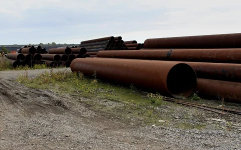 Large steel pipes stacked at an industrial estate.