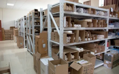 Boxes and goods stored on metal shelving in a warehouse.