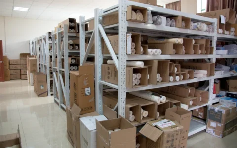 Boxes and goods stored on metal shelving in a warehouse.