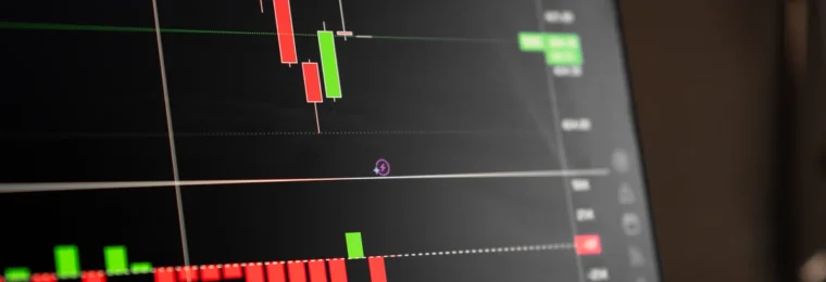 Close-up of a digital screen displaying red and green stock-market candlestick charts.