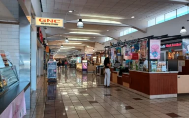 Interior of Weberstown Mall in Stockton, California, with retail storefronts and shoppers.