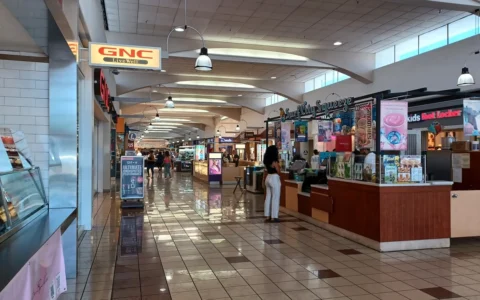 Interior of Weberstown Mall in Stockton, California, with retail storefronts and shoppers.