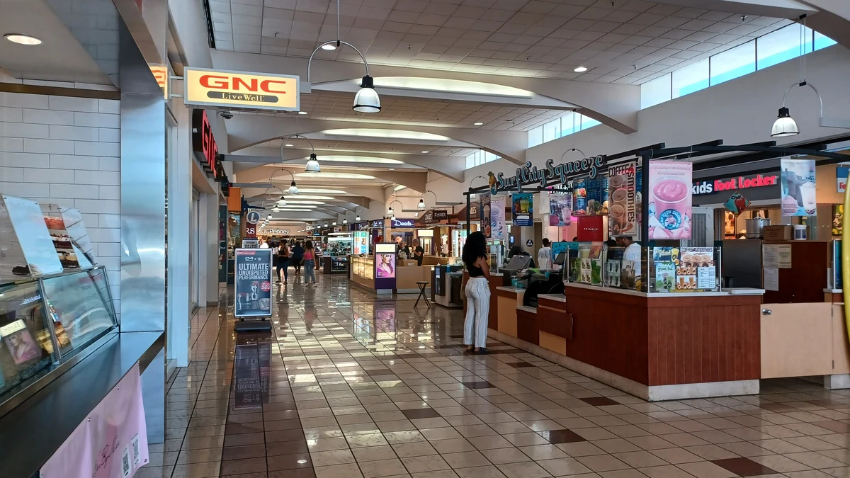 Interior of Weberstown Mall in Stockton, California, with retail storefronts and shoppers.