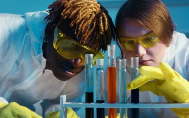 Two scientists examining laboratory samples in a biotechnology research setting.