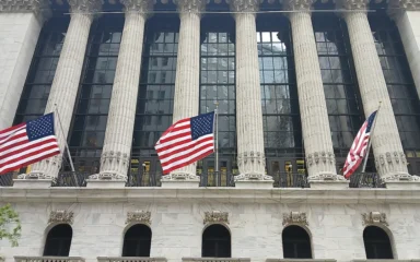 Broad Street facade of the New York Stock Exchange Building in Manhattan with American flags.