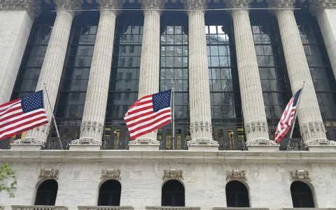 Broad Street facade of the New York Stock Exchange Building in Manhattan with American flags.