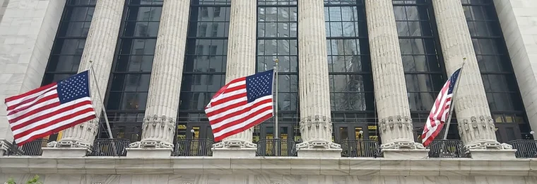 Broad Street facade of the New York Stock Exchange Building in Manhattan with American flags.