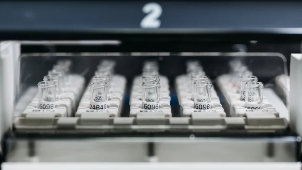 Rows of laboratory vials inside an automated scientific research machine.