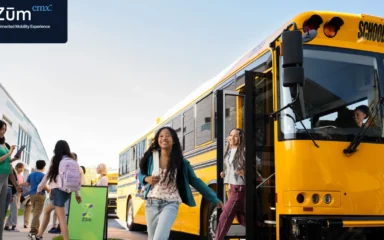 Zūm-branded school bus with students and staff.