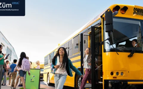 Zūm-branded school bus with students and staff.