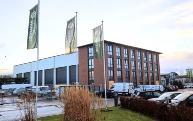 2G Energy headquarters and production building in Heek, Germany, with company flags in the foreground.