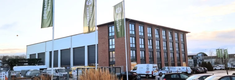 2G Energy headquarters and production building in Heek, Germany, with company flags in the foreground.