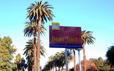 Bean Tract historic neighborhood sign along a palm-lined street in Alhambra, California.