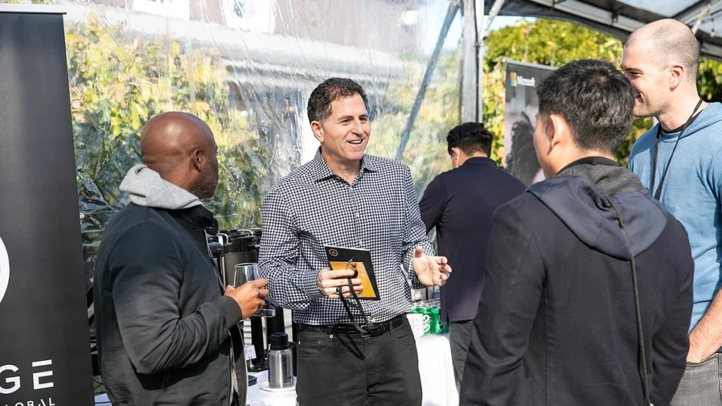 Michael Dell speaking with attendees at an outdoor event in 2021.