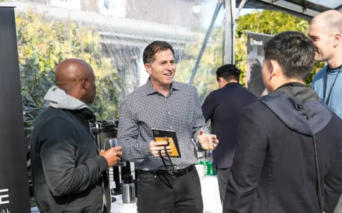 Michael Dell speaking with attendees at an outdoor event in 2021.