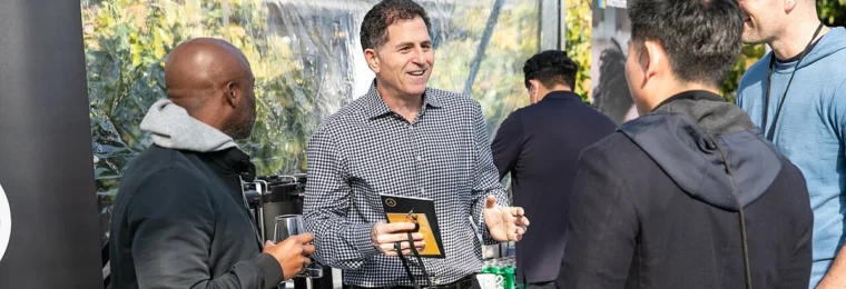 Michael Dell speaking with attendees at an outdoor event in 2021.