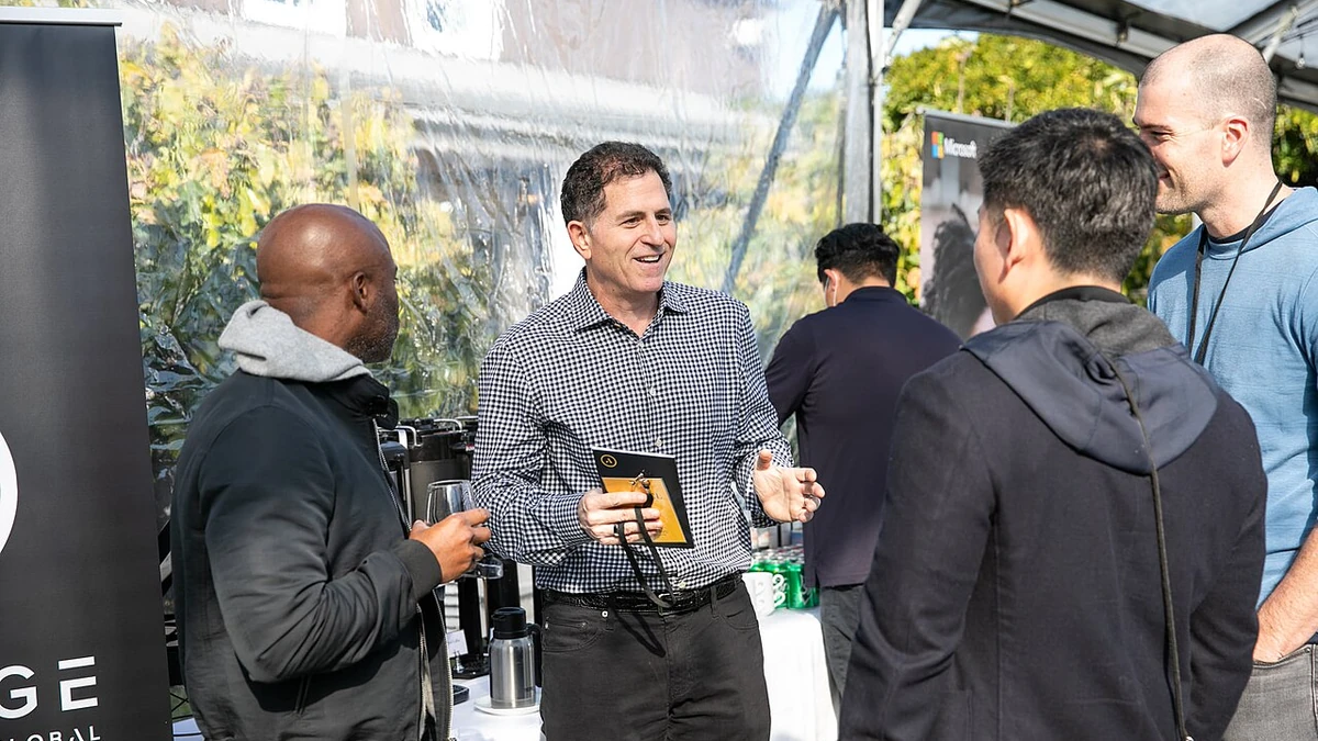 Michael Dell speaking with attendees at an outdoor event in 2021.