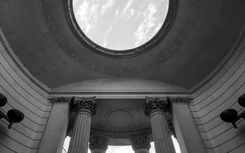Black-and-white view looking up at columns and an archway at the Bank of England Museum in London.