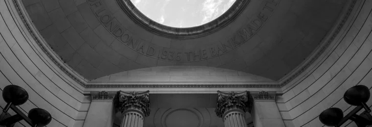 Black-and-white view looking up at columns and an archway at the Bank of England Museum in London.