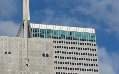 Upper portion of Republic Center in Dallas with its tower spire against a blue sky.