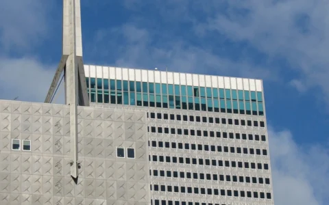 Upper portion of Republic Center in Dallas with its tower spire against a blue sky.