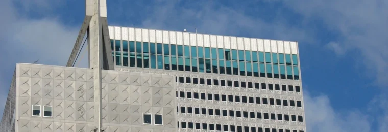 Upper portion of Republic Center in Dallas with its tower spire against a blue sky.