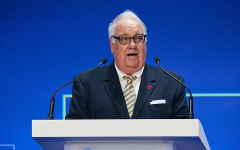 Howard G. Buffett speaking at a podium against a blue backdrop.