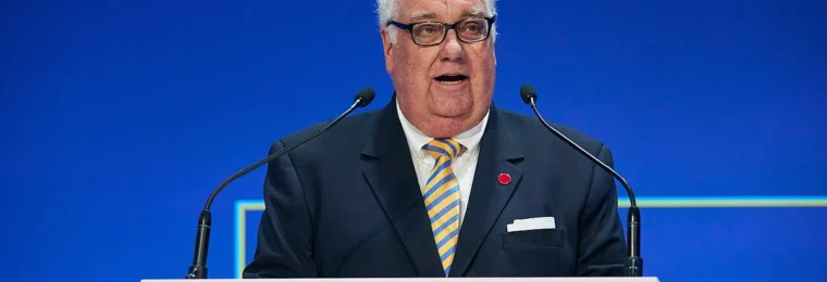 Howard G. Buffett speaking at a podium against a blue backdrop.