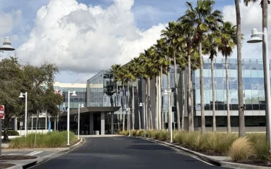 Darden Restaurants headquarters building near Orlando, Florida, with palm trees along the entrance.