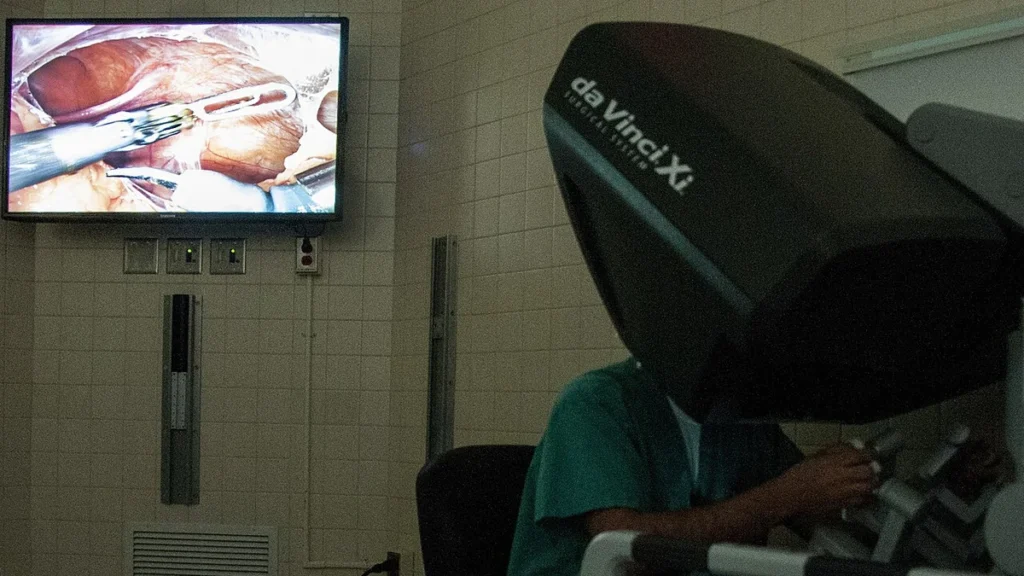Surgeon using a 3D imaging console during robotic-assisted surgery.