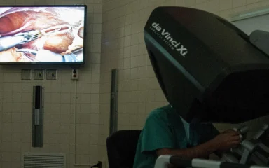 Surgeon using a 3D imaging console during robotic-assisted surgery.