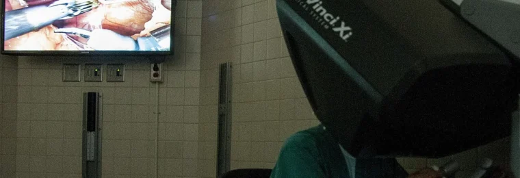 Surgeon using a 3D imaging console during robotic-assisted surgery.