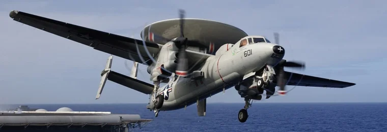A U.S. Navy E-2C Hawkeye aircraft taking off from USS Kitty Hawk at sea.