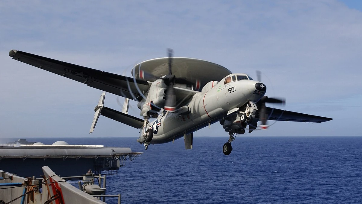 A U.S. Navy E-2C Hawkeye aircraft taking off from USS Kitty Hawk at sea.