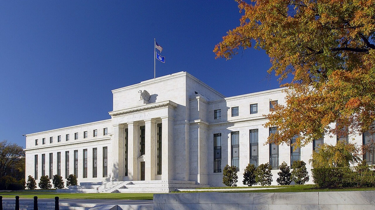 Marriner S. Eccles Federal Reserve Board building in Washington, D.C., with autumn trees in the foreground.