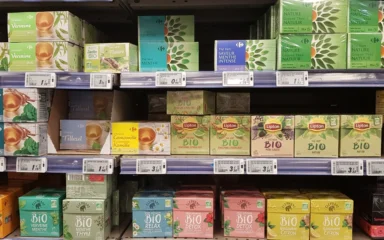 Tea products displayed on shelves in a Paris supermarket.