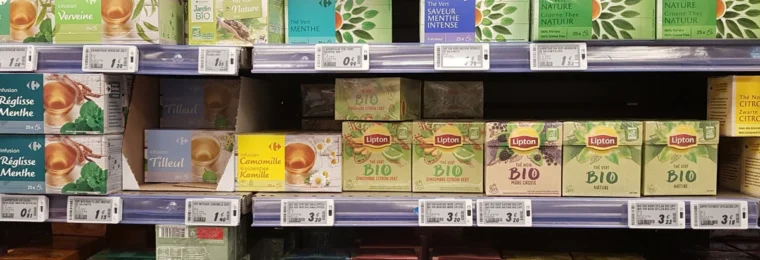 Tea products displayed on shelves in a Paris supermarket.
