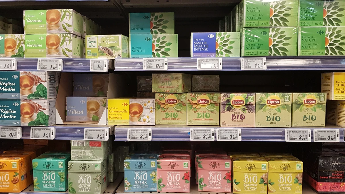 Tea products displayed on shelves in a Paris supermarket.