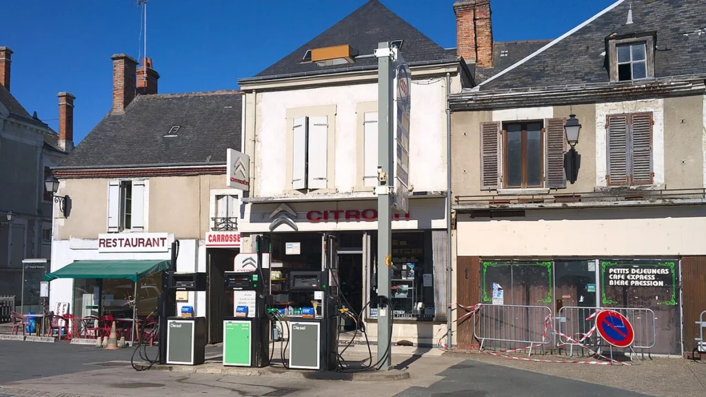 Petrol station and storefronts on Grand Rue in Vatan, France.