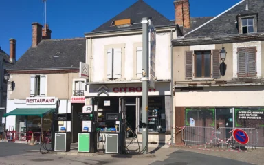 Petrol station and storefronts on Grand Rue in Vatan, France.