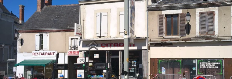 Petrol station and storefronts on Grand Rue in Vatan, France.