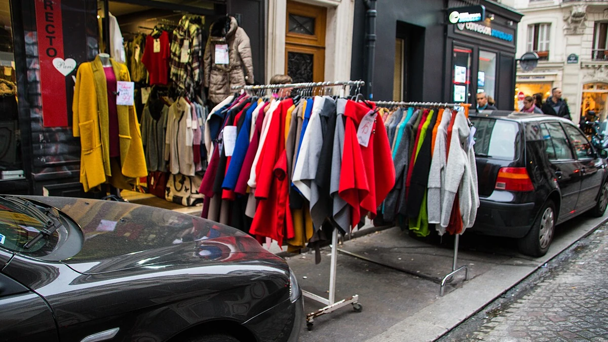 Clothing racks displayed outside a shop on a Paris street.