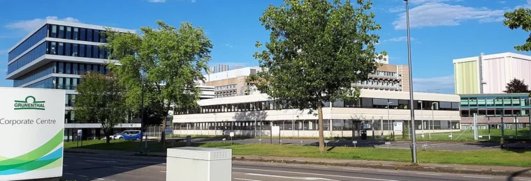 Grünenthal corporate campus in Aachen-Eilendorf, Germany, with company signage in the foreground.