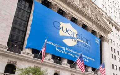 Guardian Pharmacy Services banner displayed on the New York Stock Exchange building.