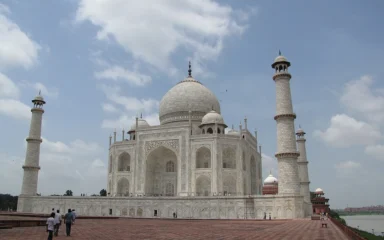 The Taj Mahal in Agra, India, beneath a partly cloudy sky.