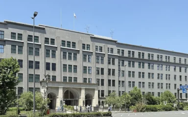 Japan Ministry of Finance headquarters building in Tokyo under a clear blue sky.