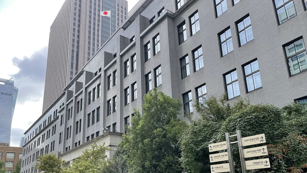 Japan's Ministry of Finance building in Tokyo, with the Japanese flag visible on the tower behind it.